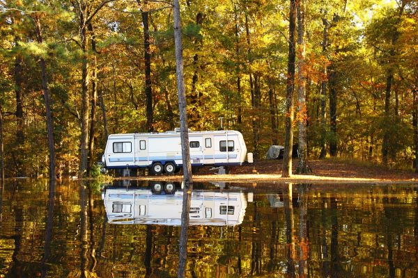 Trailer parked by a pond during the fall.