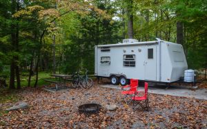 RV trailer parked in woods