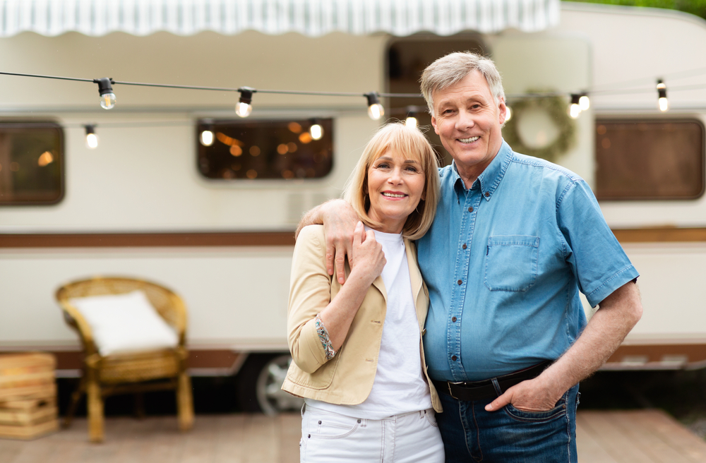 couple with RV trailer at campsite