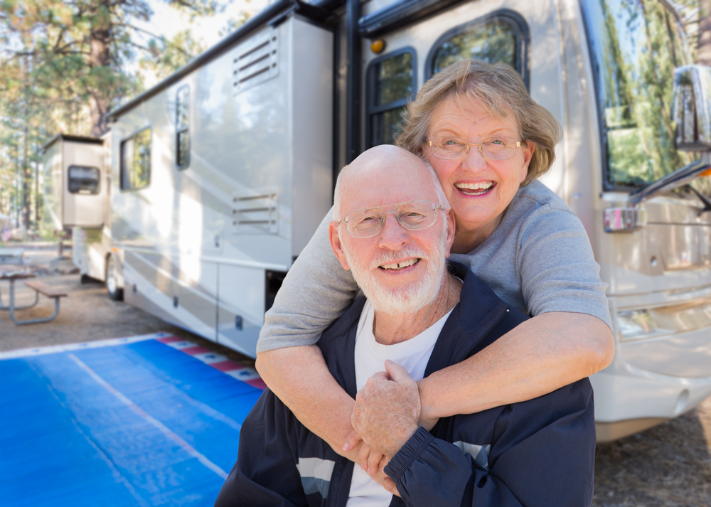 couple with RV trailer at campsite