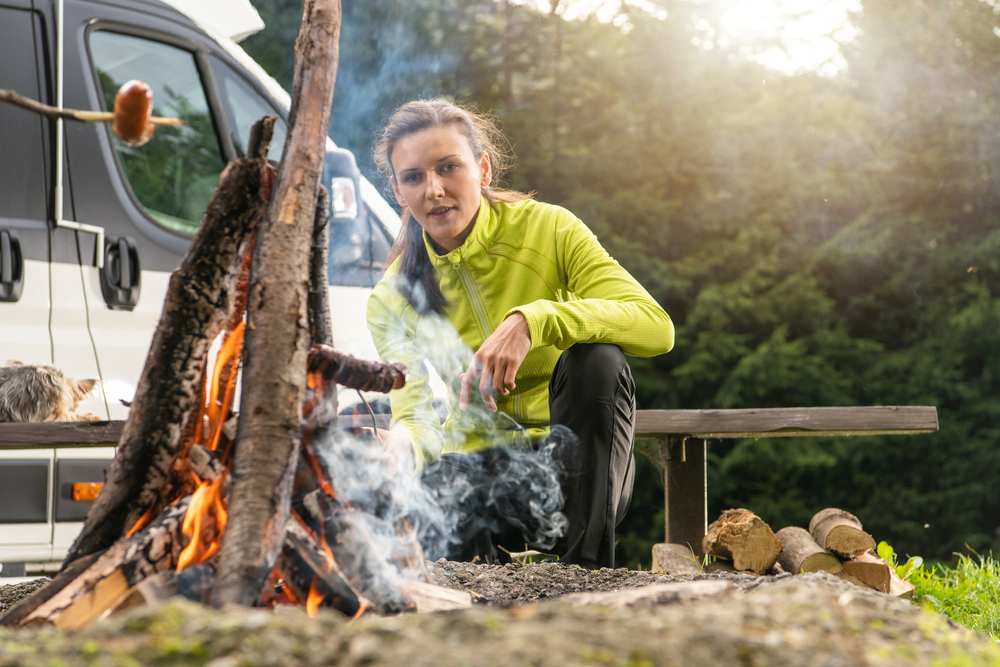 young woman with campfire and RV