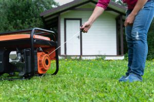person starting their portable generator