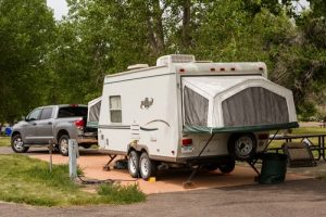 A hybrid trailer with a solid body and tent pop out on the side. 